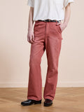 A person stands indoors on a wooden floor wearing a white T-shirt, FOUND Canvas Faded Pants with a belt, and black shoes, with one hand in their pocket.